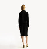 Black A line midi skirt with embossed jacquard texture built in side pockets and structured waist hem details.rear-view.
