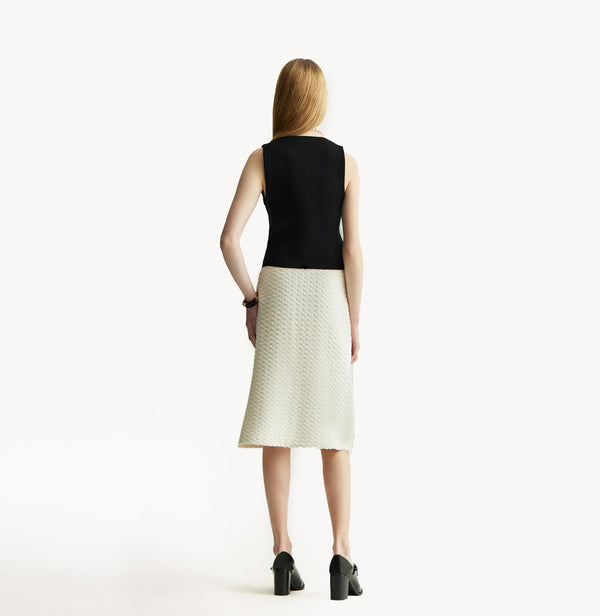 White A line midi skirt with embossed jacquard texture built in side pockets and structured waist hem details.