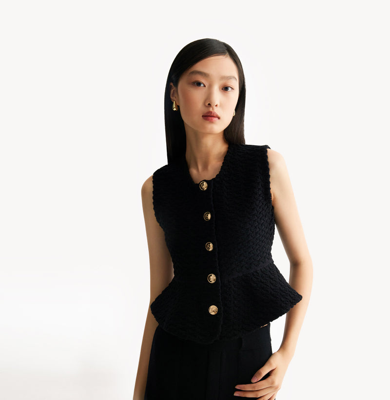 Black womens fitted vest in wool blend stretch fabric with cinched waist flared hem and seamless edge trim. left-view.