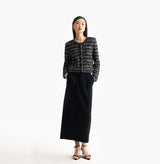 Black female tweed jacket with crewneck, four front pockets, velvet metal logo buttons, and buttoned sleeve vents.