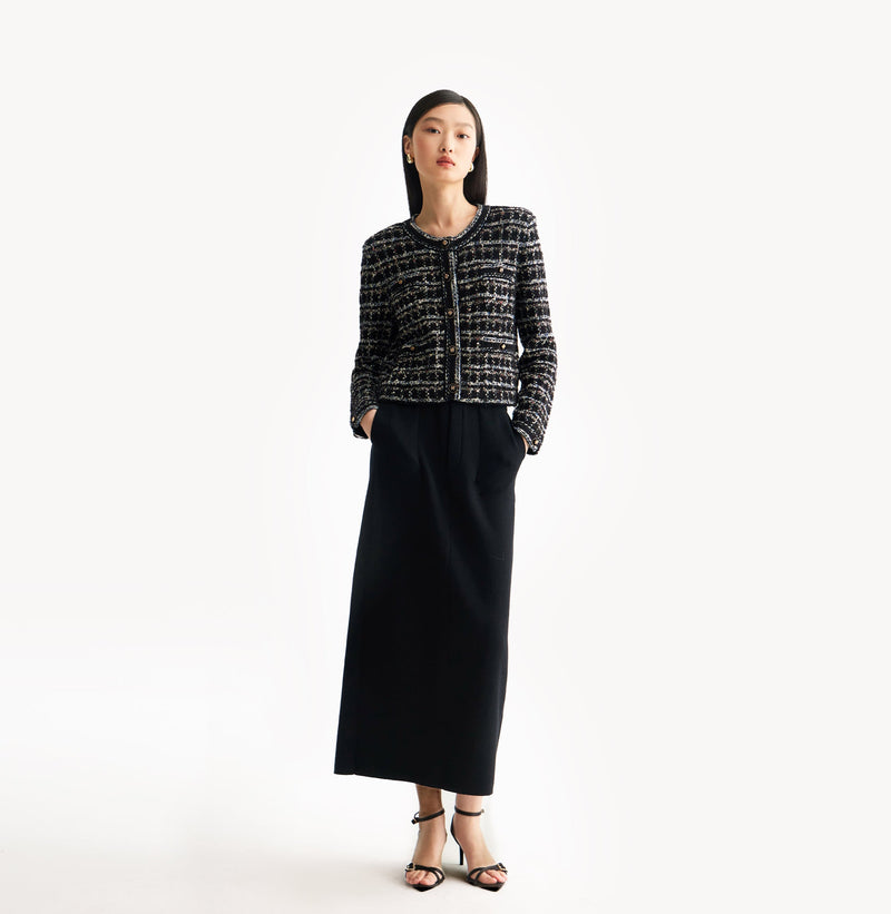 Black female tweed jacket with crewneck, four front pockets, velvet metal logo buttons, and buttoned sleeve vents.