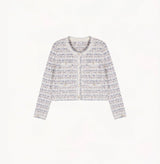 White female tweed jacket with crewneck, four front pockets, velvet metal logo buttons, and buttoned sleeve vents.