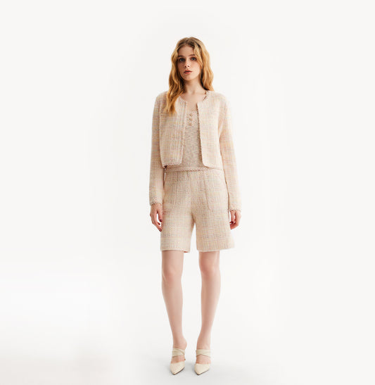 Woman wearing a pink cardigan on a white background, front-view