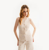 Woman wearing a pink crewneck vest on a white background, left-view