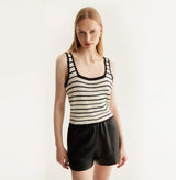 Black sheepskin shorts with relaxed pleated design and elastic waistband.