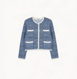 Blue tweed jacket with contrast ribbed trim, signature metal buttons, and subtle sequin details.