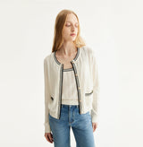 White colorblock cotton cardigan with fitted silhouette, crewneck, contrasting trim details, and decorative metal buttons. left-view