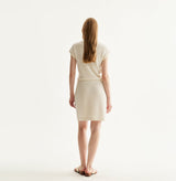 White silk-cotton dress with fitted silhouette, cap sleeves, and decorative front pockets. rear-view