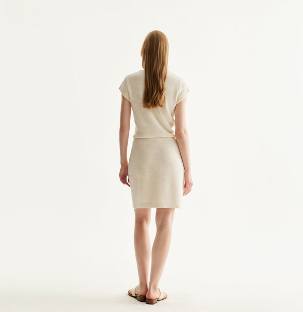 White silk-cotton dress with fitted silhouette, cap sleeves, and decorative front pockets. rear-view