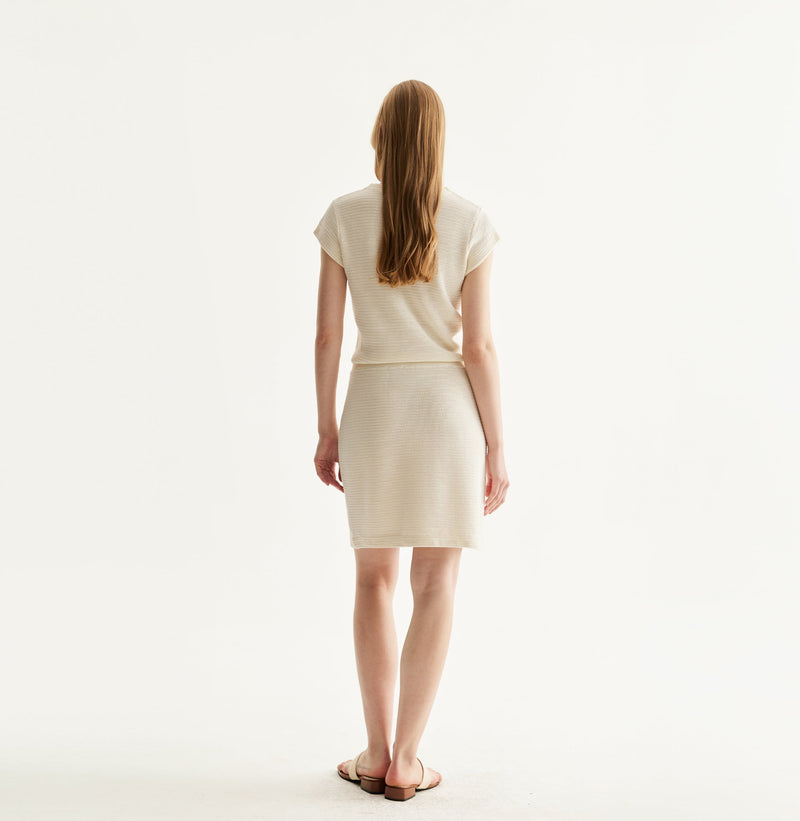 White silk-cotton dress with fitted silhouette, cap sleeves, and decorative front pockets. rear-view