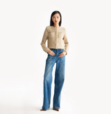 Beige ladies cropped boucle jacket in cashmere blend with shoulder padding, folded edges, and double-layered pocket flaps. 