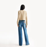 Beige ladies cropped boucle jacket in cashmere blend with shoulder padding, folded edges, and double-layered pocket flaps. 