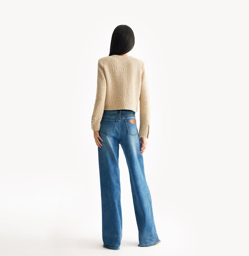 Beige ladies cropped boucle jacket in cashmere blend with shoulder padding, folded edges, and double-layered pocket flaps. 