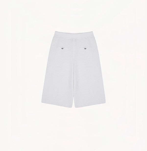 White cotton-linen shorts with relaxed wide-leg cut, petal trims, and pointelle waistband.