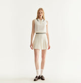White cotton pleated mini skirt with loose flared silhouette and contrasting trim waistband. front-view