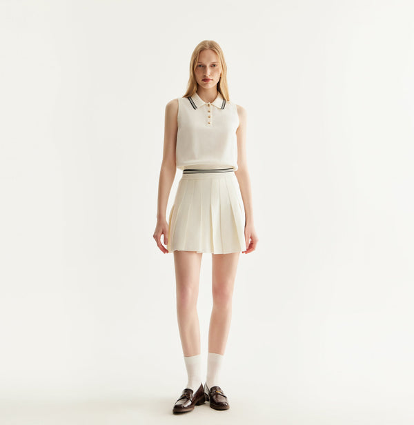 White cotton pleated mini skirt with loose flared silhouette and contrasting trim waistband. front-view