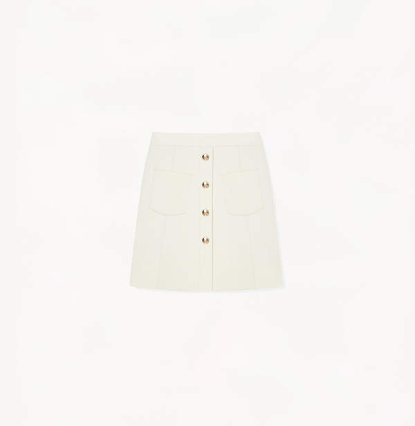 White skirt with pockets and buttons.